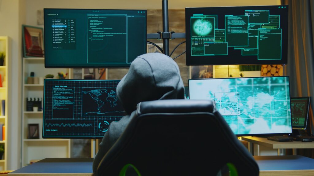 Hacker wearing a hoodie while committing cyber crimes