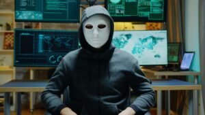 Dangerous hacker hiding his identity wearing a white mask